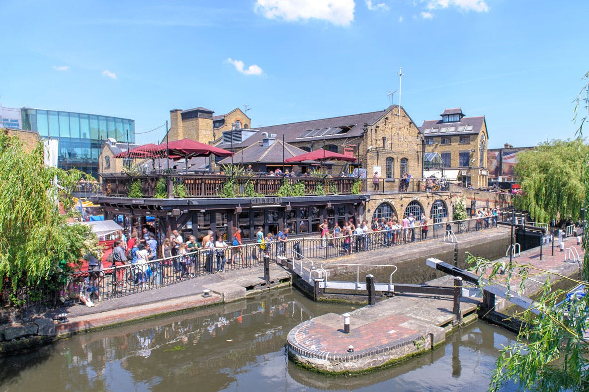 A commercial property located by the river, surrounded by people, is insured under a commercial property policy provided by Alan Boswell Group.