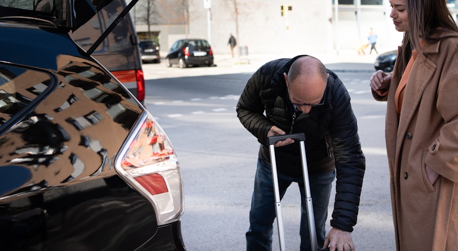 Taxi driver with public liability insurance holding luggage